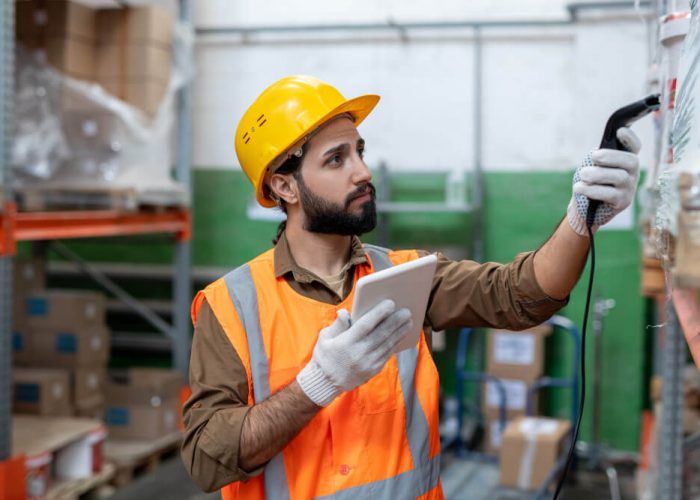 serious-young-bearded-man-hardhat-gloves-scanning-code-item-while-doing-stock-inventory-storeroom (1)